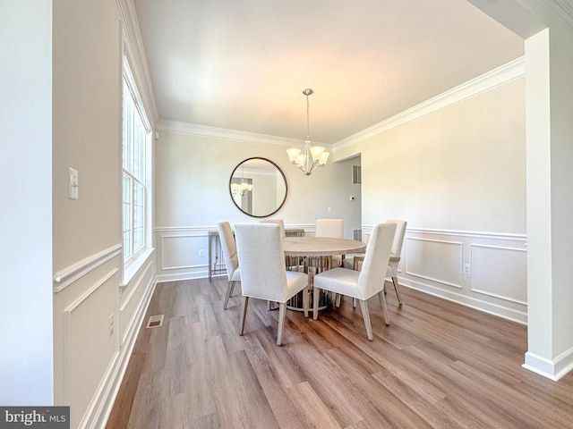 8525 Laroque Run Dr, Fredericksburg, VA 22407 - dining room with a decorative wall, wood finished floors, a chandelier, a wainscoted wall, and crown molding