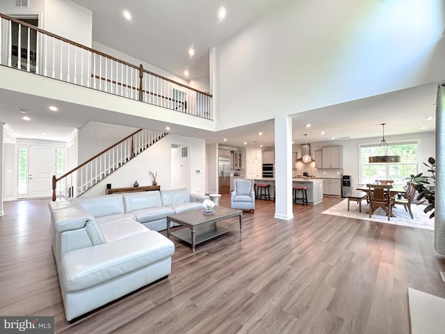 8525 Laroque Run Dr, Fredericksburg, VA 22407 - living area featuring light wood-style flooring, stairs, a towering ceiling, recessed lighting, and baseboards