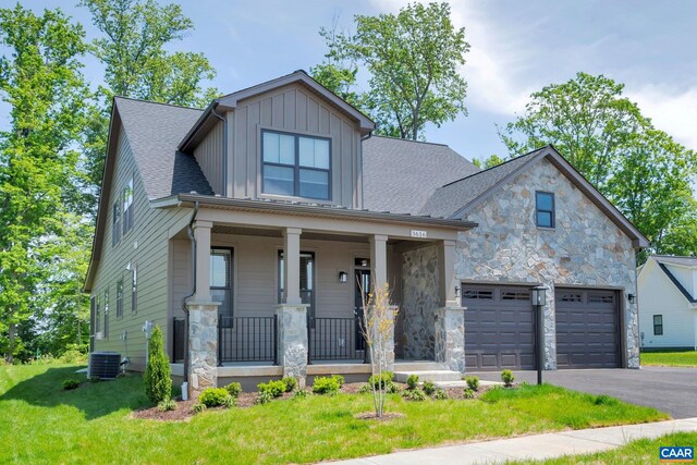 view of front facade featuring covered porch, stone siding, a garage, aphalt driveway, and board and batten siding