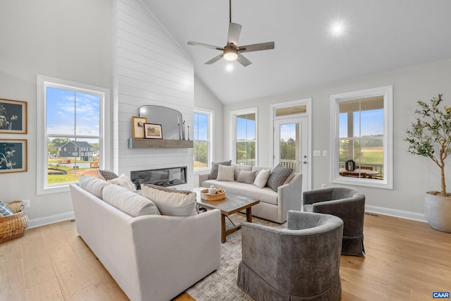 living room featuring light wood finished floors, ceiling fan, and a healthy amount of sunlight