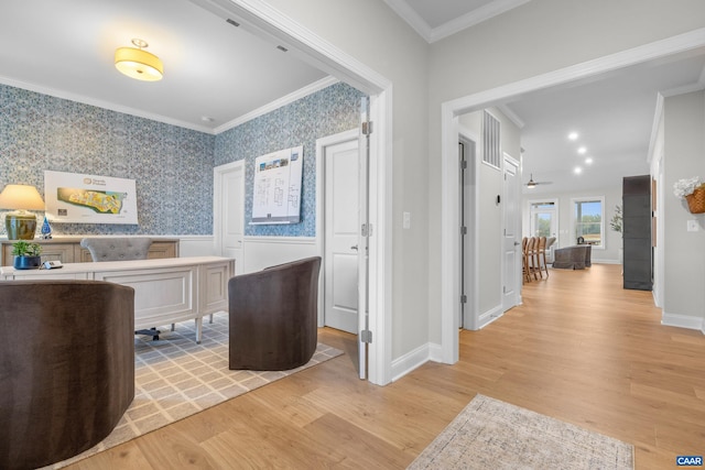 interior space featuring baseboards, ornamental molding, light wood-style flooring, and a wainscoted wall