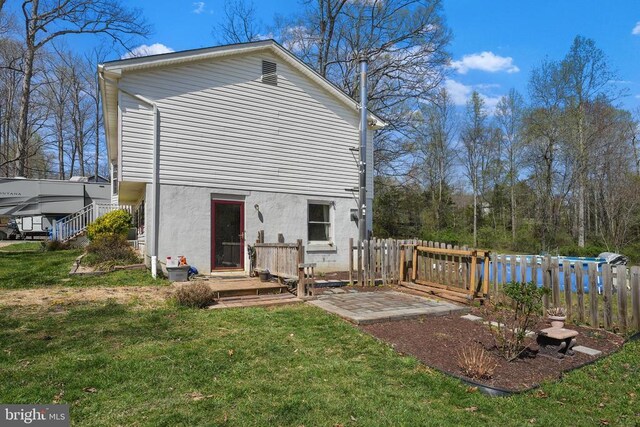 rear view of property featuring stucco siding and a deck