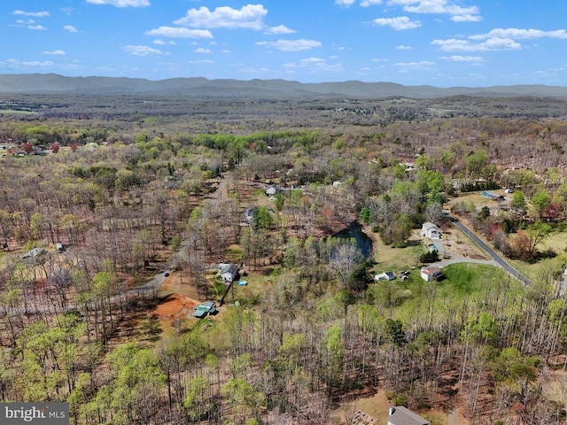 view of property location with mountains and a heavily wooded area