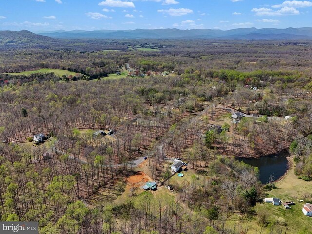 aerial view of property and surrounding area featuring a forest and mountains