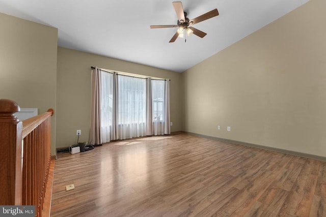 unfurnished living room featuring wood finished floors, vaulted ceiling, ceiling fan, and baseboards