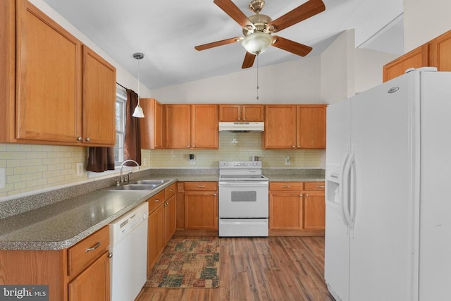 kitchen with white appliances, a sink, under cabinet range hood, vaulted ceiling, and wood finished floors
