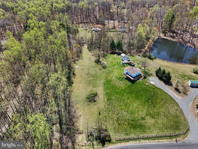 view of property location featuring a large body of water and a heavily wooded area