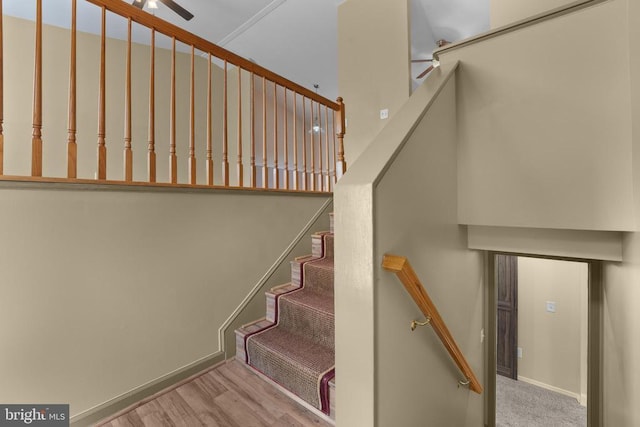 stairway featuring ceiling fan, wood finished floors, and baseboards