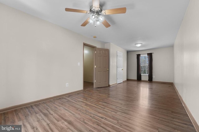 unfurnished room featuring wood finished floors, baseboards, and ceiling fan