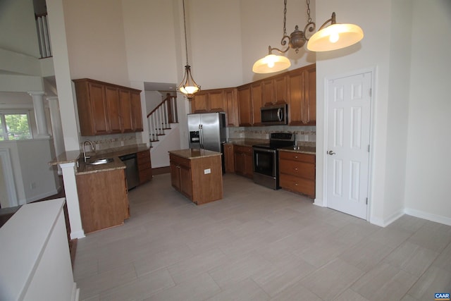 66 Timber Ridge Ln, Zion Crossroads, VA 22942 - kitchen featuring stainless steel appliances, a high ceiling, backsplash, brown cabinets, and a center island