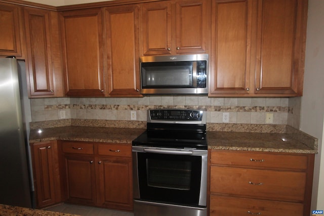66 Timber Ridge Ln, Zion Crossroads, VA 22942 - kitchen featuring stainless steel appliances, brown cabinets, backsplash, and dark stone counters