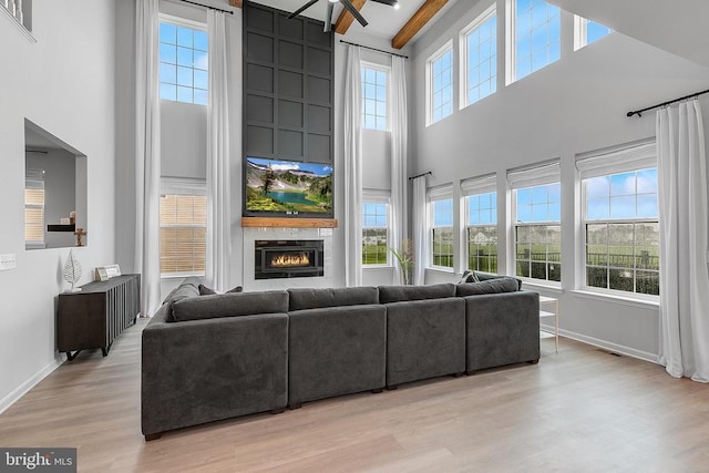 10115 Premier St, Fredericksburg, VA 22408 - living area with a high ceiling, light wood-style flooring, a fireplace, and baseboards