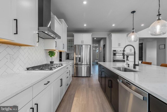 10115 Premier St, Fredericksburg, VA 22408 - kitchen featuring appliances with stainless steel finishes, wall chimney range hood, a sink, hanging light fixtures, and wood finished floors