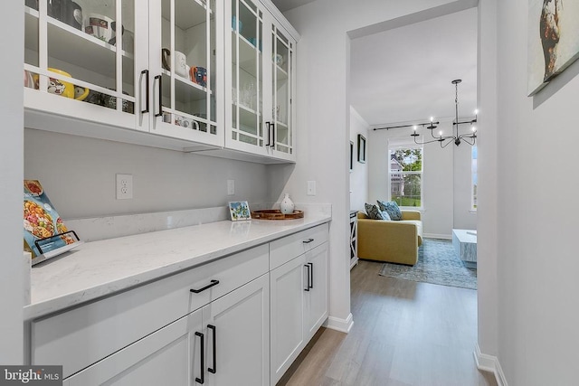 10115 Premier St, Fredericksburg, VA 22408 - bar featuring light wood-style flooring, a chandelier, and baseboards