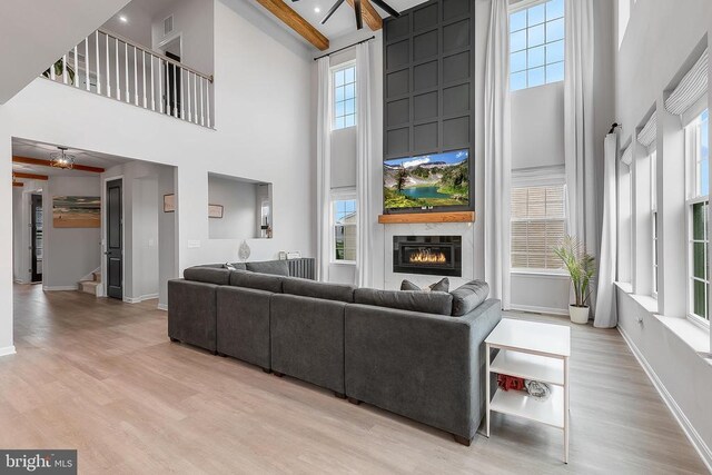 10115 Premier St, Fredericksburg, VA 22408 - living room with a high ceiling, a ceiling fan, light wood finished floors, a fireplace, and baseboards