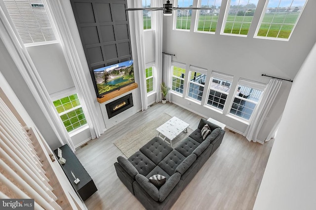 10115 Premier St, Fredericksburg, VA 22408 - living area with a high ceiling, a large fireplace, a ceiling fan, wood finished floors, and plenty of natural light