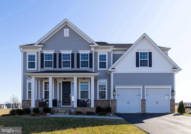 10115 Premier St, Fredericksburg, VA 22408 - view of front of home featuring a porch, a garage, driveway, stone siding, and a front lawn