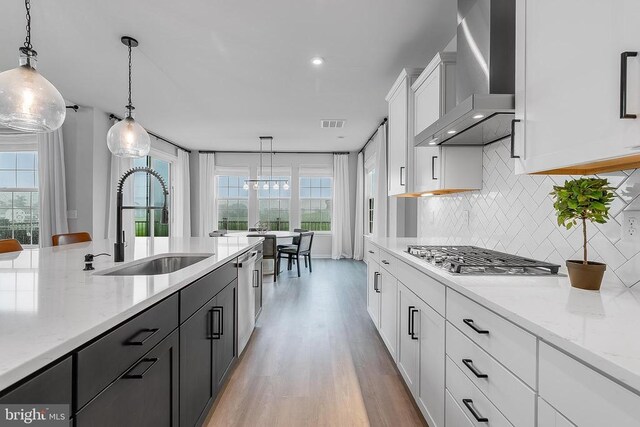 10115 Premier St, Fredericksburg, VA 22408 - kitchen with wall chimney range hood, a sink, appliances with stainless steel finishes, white cabinets, and decorative backsplash