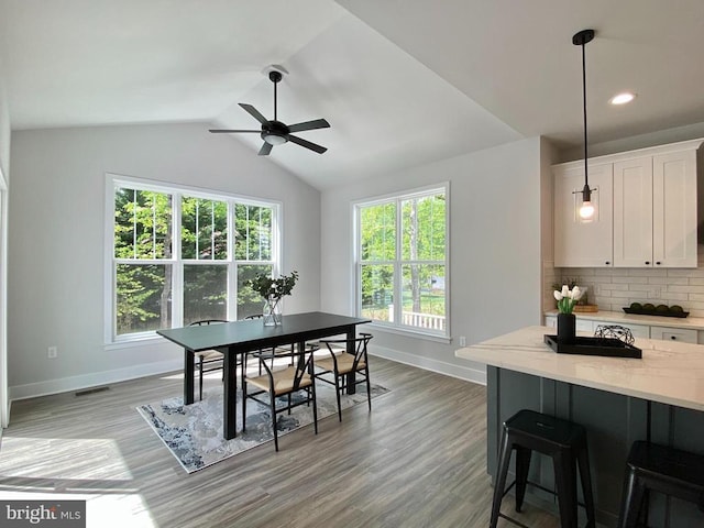dining space featuring baseboards, ceiling fan, plenty of natural light, lofted ceiling, and recessed lighting