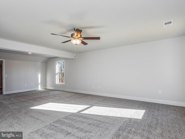 carpeted spare room featuring a ceiling fan and baseboards