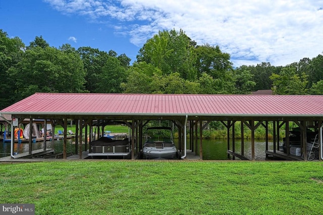 dock area featuring boat lift, a yard, and a water view