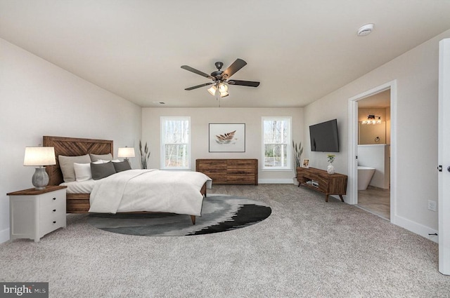 carpeted bedroom featuring baseboards, connected bathroom, and a ceiling fan