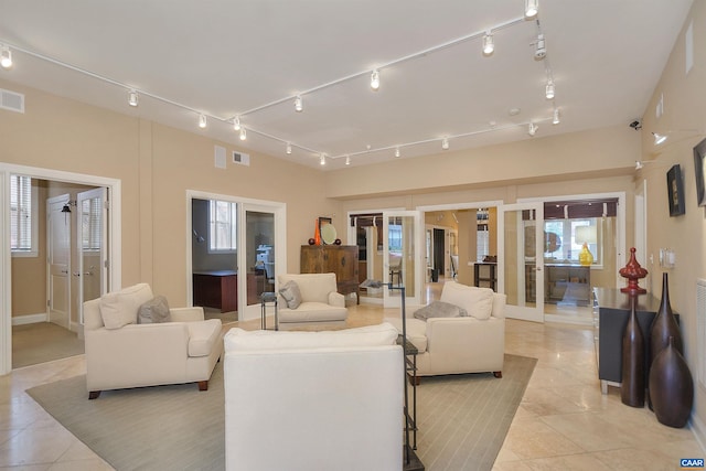 living room featuring rail lighting, light tile patterned flooring, french doors, and visible vents