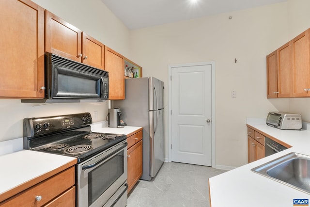 kitchen with baseboards, brown cabinets, light countertops, and appliances with stainless steel finishes