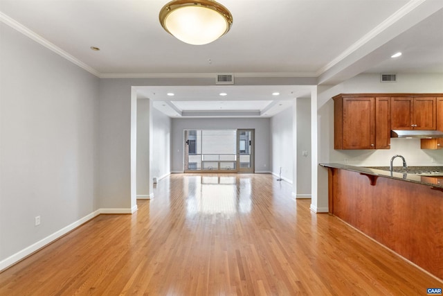 112 5th St SE Unit 3D, Charlottesville, VA 22902 - kitchen with under cabinet range hood, brown cabinetry, light wood-style flooring, open floor plan, and baseboards