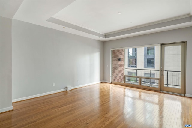 112 5th St SE Unit 3D, Charlottesville, VA 22902 - spare room with a raised ceiling, wood finished floors, ornamental molding, and baseboards