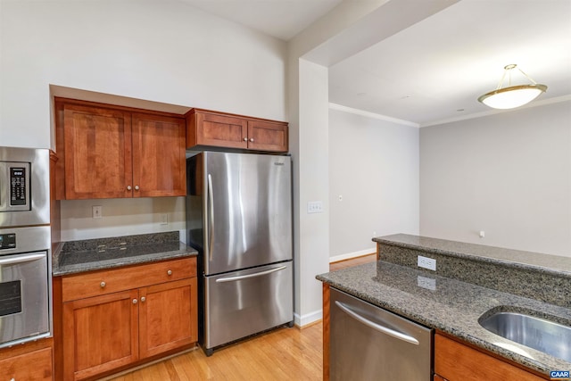 112 5th St SE Unit 3D, Charlottesville, VA 22902 - kitchen with appliances with stainless steel finishes, light wood-type flooring, dark stone countertops, brown cabinets, and ornamental molding