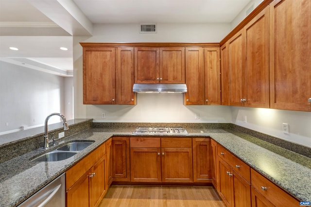 112 5th St SE Unit 3D, Charlottesville, VA 22902 - kitchen featuring a sink, stainless steel appliances, under cabinet range hood, dark stone countertops, and brown cabinets