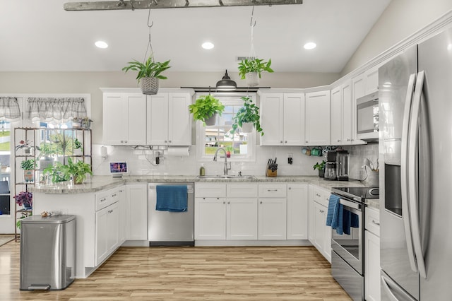 96 Lofty Cir, Stuarts Draft, VA 24477 - kitchen featuring stainless steel appliances, a peninsula, light wood-style floors, backsplash, and lofted ceiling