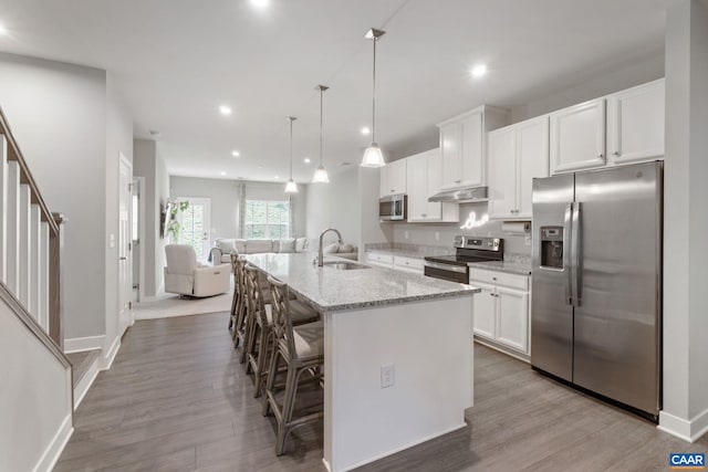 712 Empire St, Charlottesville, VA 22901 - kitchen featuring stainless steel appliances, under cabinet range hood, white cabinetry, a center island with sink, and recessed lighting