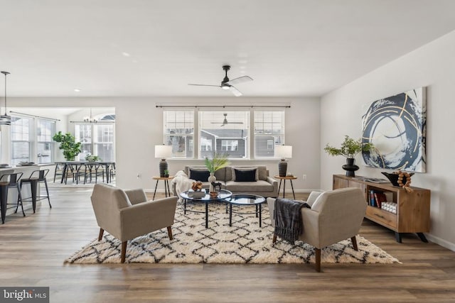 living area featuring plenty of natural light, wood finished floors, and a chandelier