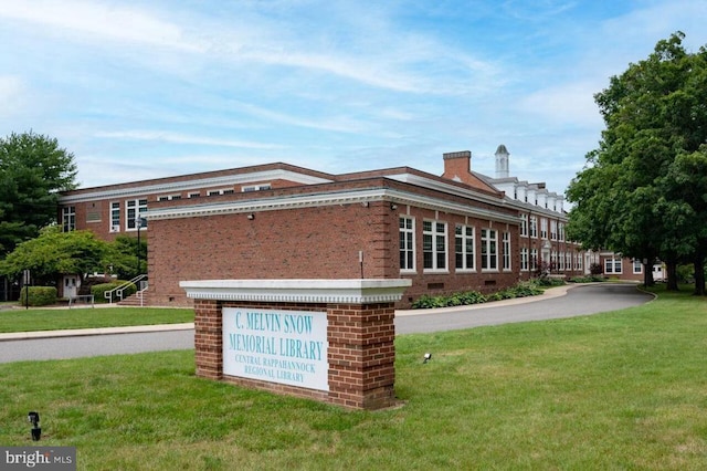 view of home's exterior with brick siding and a yard
