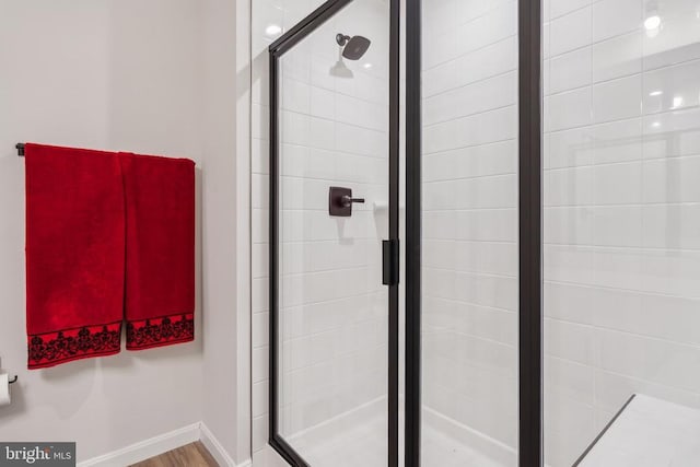 bathroom featuring a shower stall and baseboards