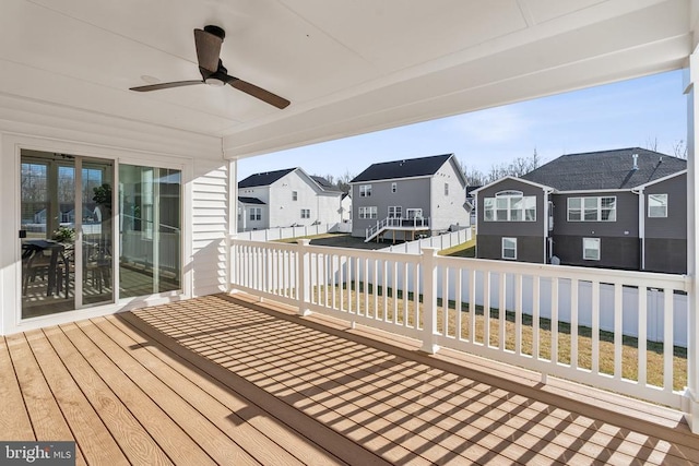 wooden terrace featuring a residential view, ceiling fan, and fence