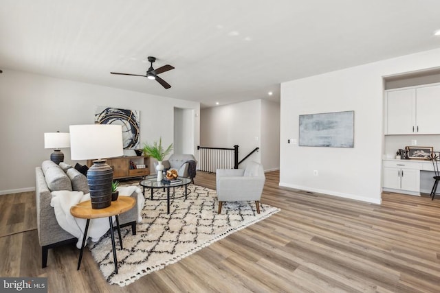 living area featuring light wood-style floors, a ceiling fan, recessed lighting, and baseboards