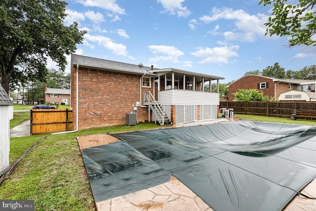 12016 Branchwater St, Fredericksburg, VA 22407 - rear view of house featuring brick siding, a sunroom, and central air condition unit