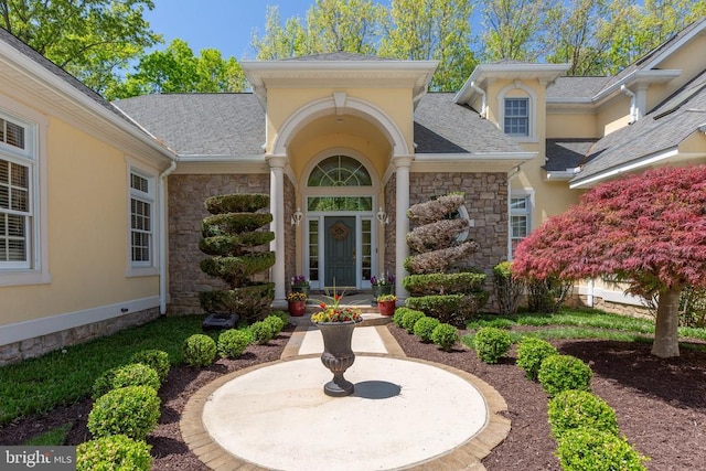 11306 Stonewall Jackson Dr, Spotsylvania, VA 22551 - view of exterior entry with stone siding, stucco siding, and roof with shingles