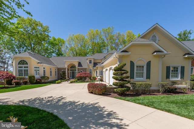 11306 Stonewall Jackson Dr, Spotsylvania, VA 22551 - view of front of property featuring driveway, a garage, stucco siding, and a front yard