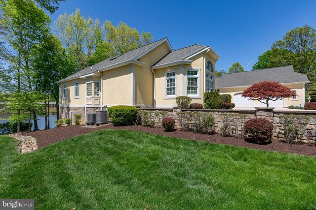 11306 Stonewall Jackson Dr, Spotsylvania, VA 22551 - view of front of property with stucco siding, a front yard, a garage, and stone siding