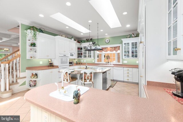 11306 Stonewall Jackson Dr, Spotsylvania, VA 22551 - kitchen featuring open shelves, a skylight, crown molding, white cabinets, and healthy amount of natural light