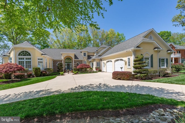 11306 Stonewall Jackson Dr, Spotsylvania, VA 22551 - view of front of home featuring a garage, concrete driveway, stucco siding, and a front lawn