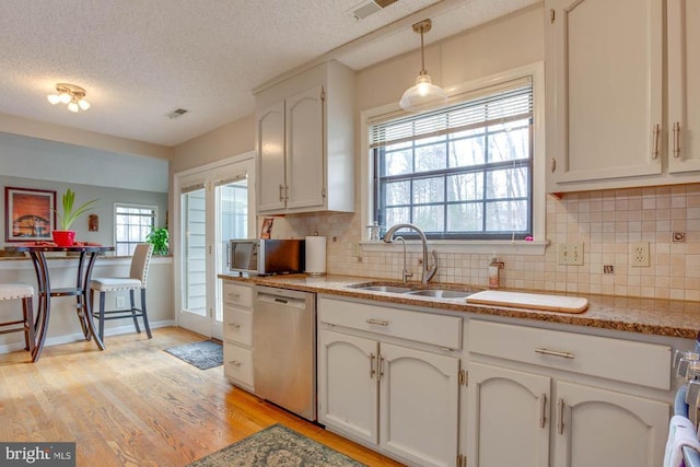47 Marwood Dr, Palmyra, VA 22963 - kitchen with light wood finished floors, a sink, a textured ceiling, stainless steel dishwasher, and tasteful backsplash