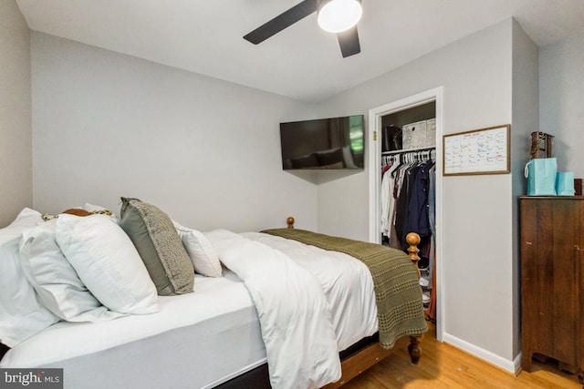  - bedroom featuring wood finished floors, a closet, a spacious closet, ceiling fan, and baseboards
