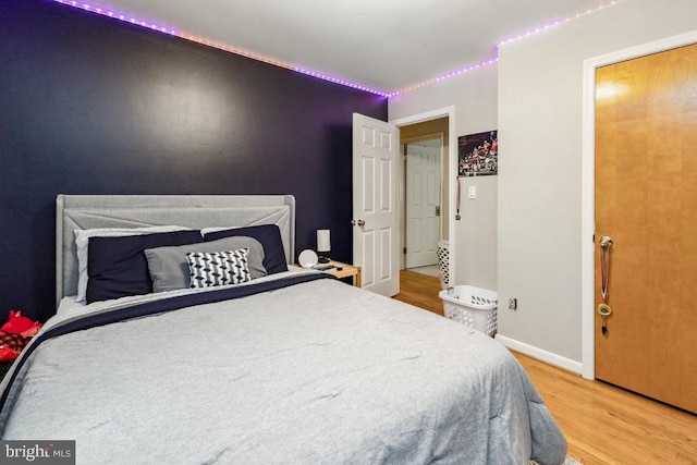  - bedroom featuring wood finished floors and baseboards