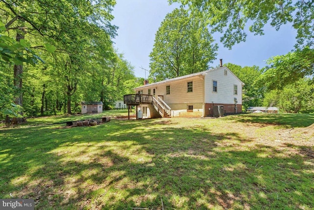  - rear view of house with stairs, a wooden deck, a lawn, and central AC