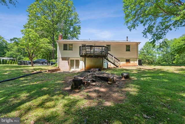  - rear view of property featuring a chimney, a deck, a lawn, and stairs
